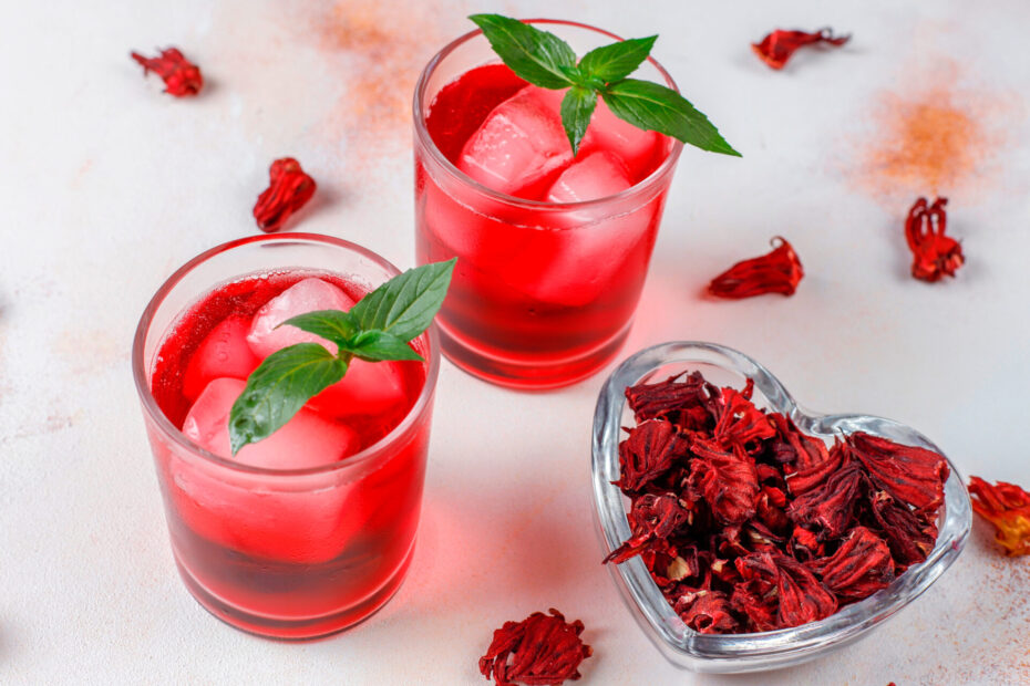 Cold brew hibiscus tea with ice and basil leaves.